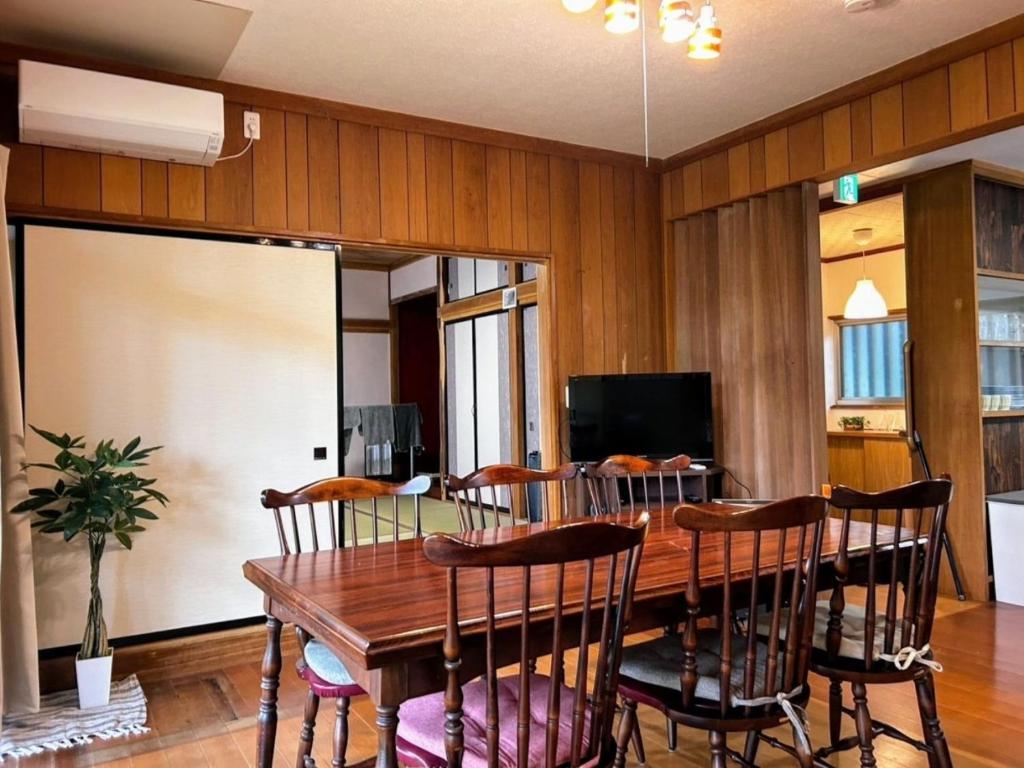 Un comedor con mesa y sillas de madera. en Solarium Komoro - Vacation STAY 84700v, en Komoro