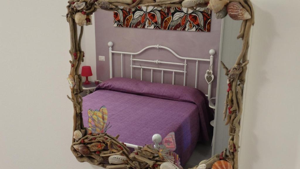 a bedroom with a bed with a purple blanket at Casetta Romantica Viola Lerici in Lerici