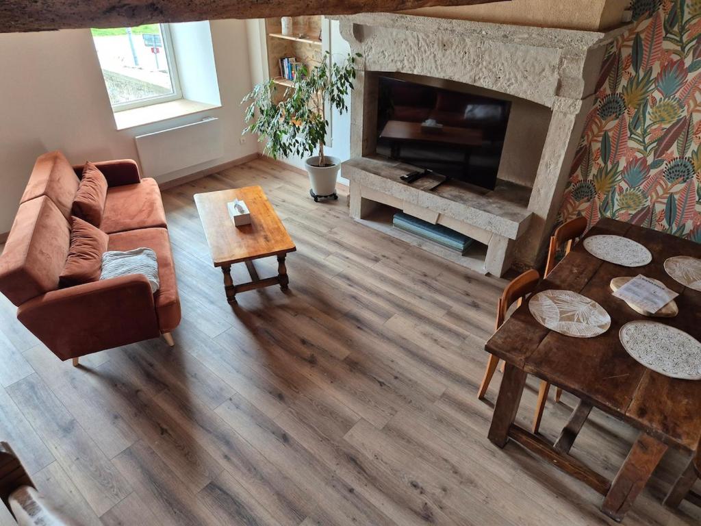 un salon avec un canapé et une cheminée dans l'établissement Jolie maison de campagne, à Rauville-la-Place