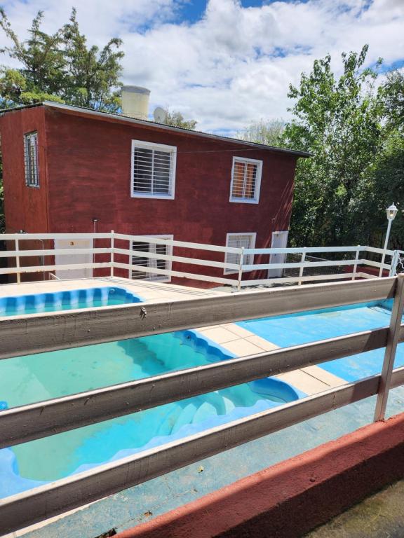 una casa con piscina delante de una casa en Altos de Grecia Cabaña 3, en Villa Carlos Paz