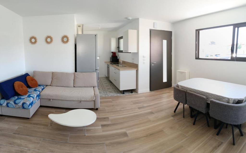 un salon avec un canapé et une table dans l'établissement Maison neuve en centre-ville, à Saint-Hilaire-de-Riez
