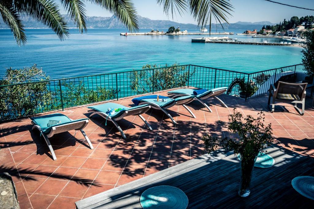 a patio with chairs and a view of the water at Apartments Maestral in Trpanj