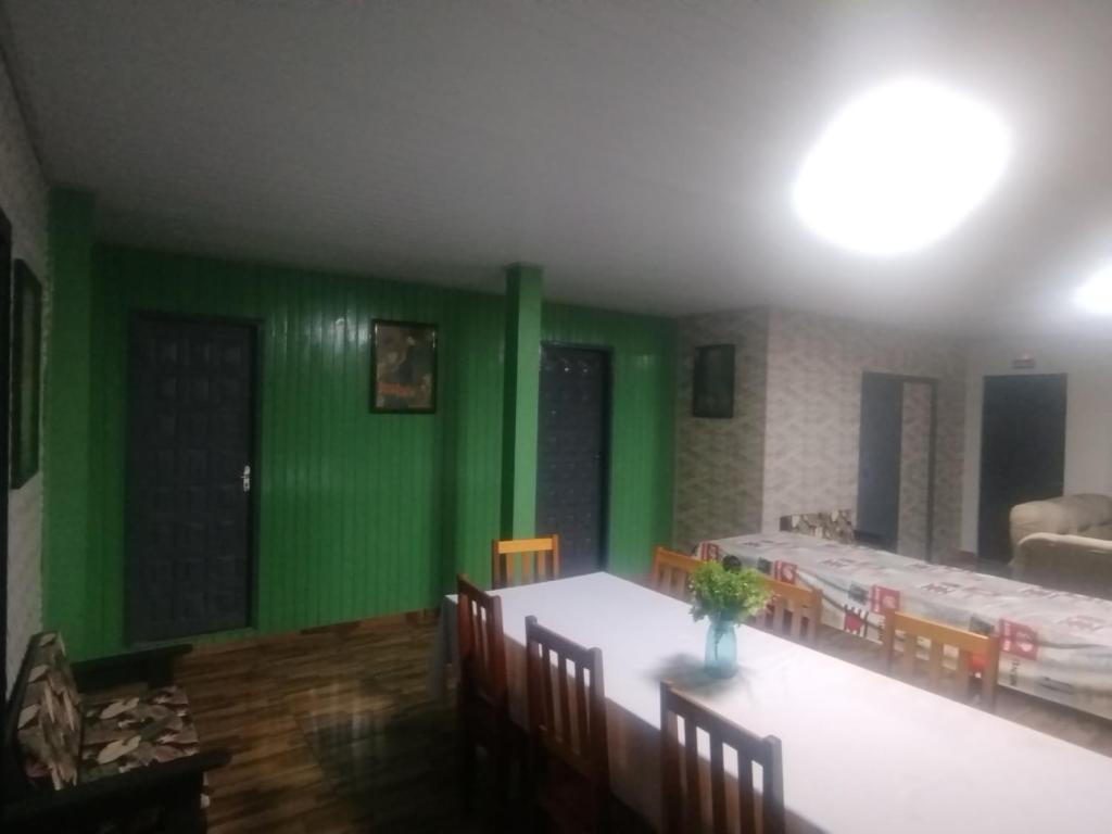 a room with green walls and a table and chairs at Pousada Bella Montanha in Louro Müller