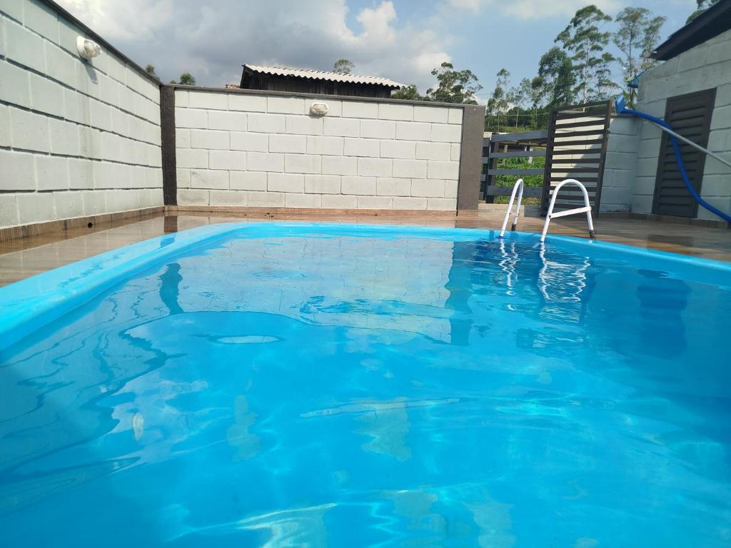 a large blue swimming pool with a hose at Pousada Bella Montanha in Lauro Müller