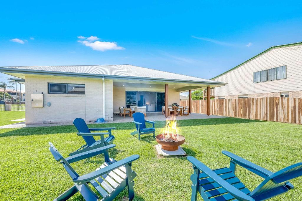 a backyard with chairs and a fire pit at Burnett Heads Family Escape in Burnett Heads