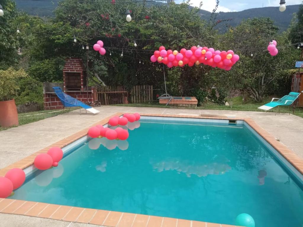 a bunch of pink balloons floating above a swimming pool at Finca Santa María Del Lago in Piedecuesta