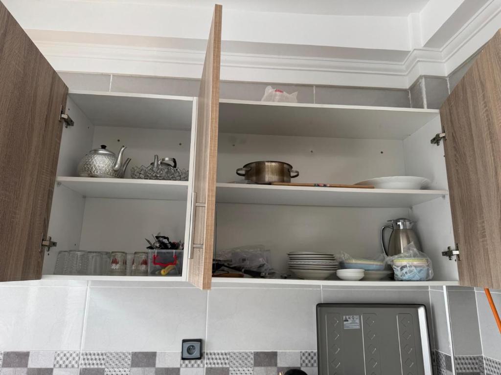 a kitchen with a cupboard filled with lots of dishes at Mini Villa Al Hoceima in Al Hoceïma