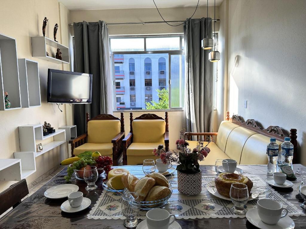 a living room with a table with bread on it at Apto na beira da praia do Centro | ROMM207 in Rio das Ostras