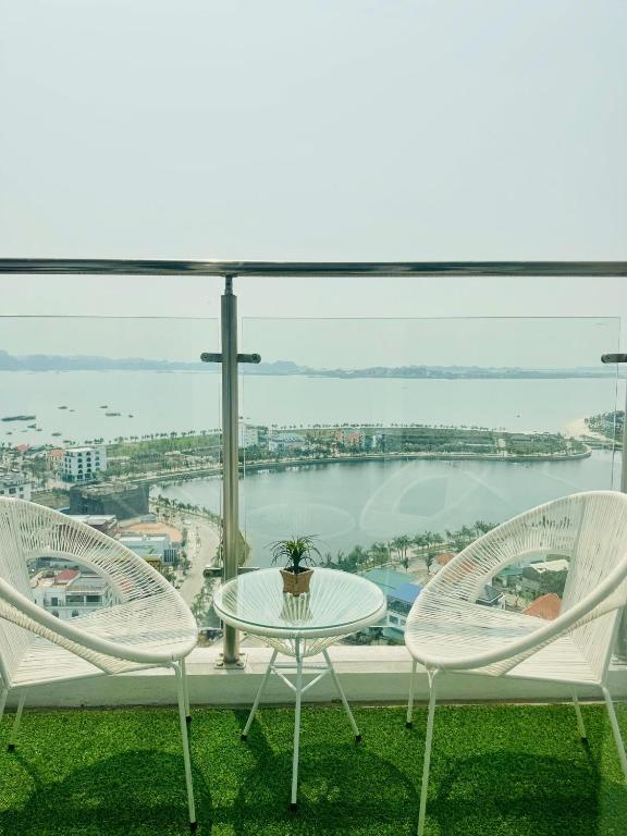 two chairs and a table on a balcony with a view at HOMESTAY CAO CẤP TẠI NEWLIFE HẠ LONG 2PN in Ha Long