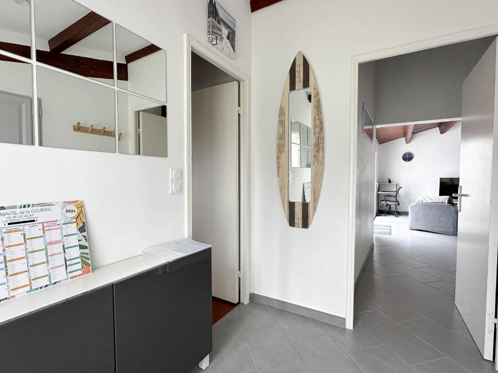 un couloir avec des murs blancs et un miroir dans l'établissement Villa moderne 4 pièces, 6 pers, proche mer, WIFI, animaux OK, parking - FR-1-705-13, à La Palmyre