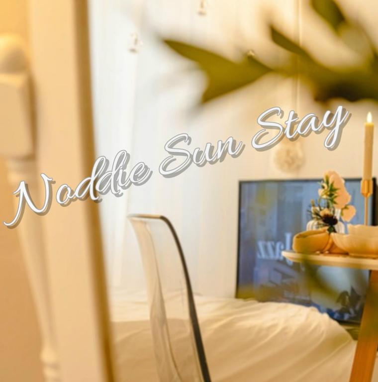a sign that reads variable sun stay with a bed and a table at Noddle Sun Stay in Seoul