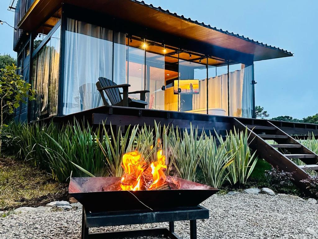 a fire pit in front of a house at Cabana Black BIRD l, morro da igreja Urubici SC in Urubici