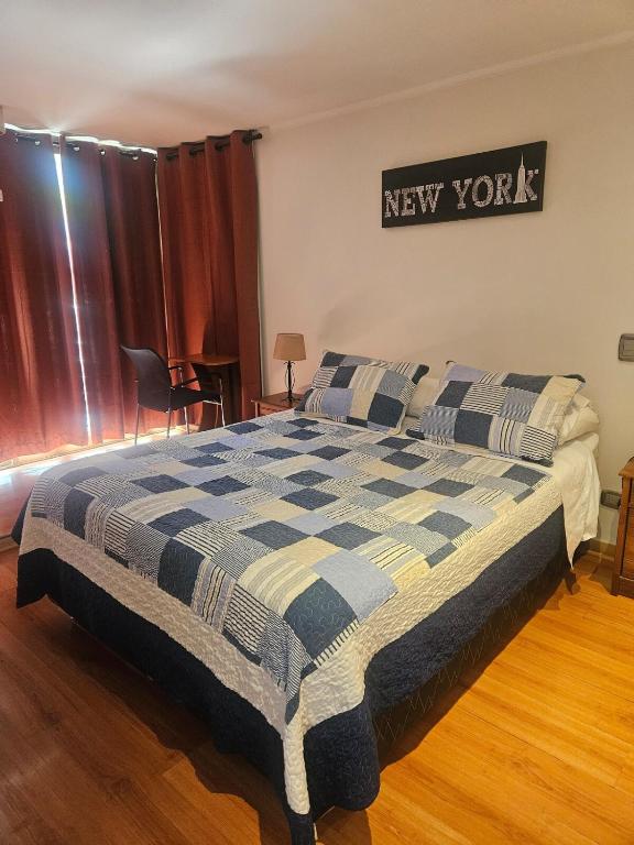 a bedroom with a bed with a new york sign on the wall at San Ignacio Suite Apoquindo MQ3 in Santiago