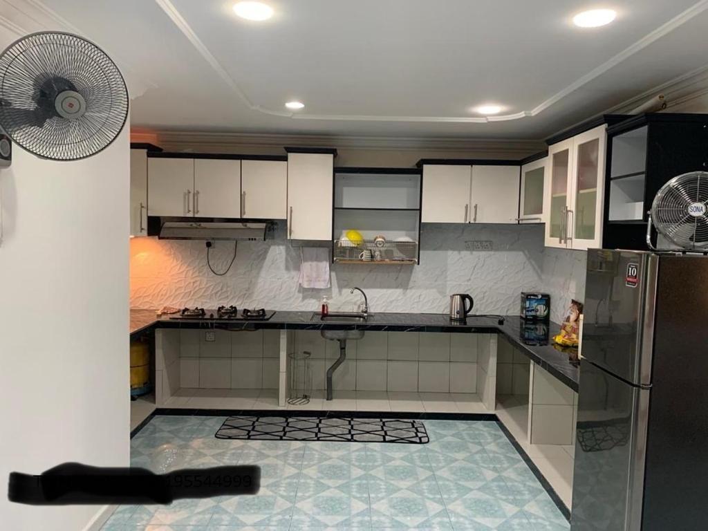 kuchnia z lodówką i wentylatorem w obiekcie Thind's Place w mieście Kamunting