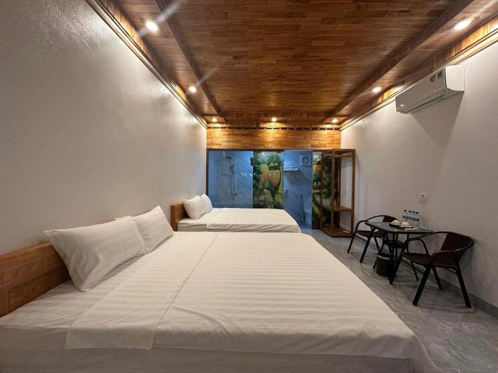 Un dormitorio con dos camas y una mesa. en Tràng An ChiDu Homestay, en Ninh Binh