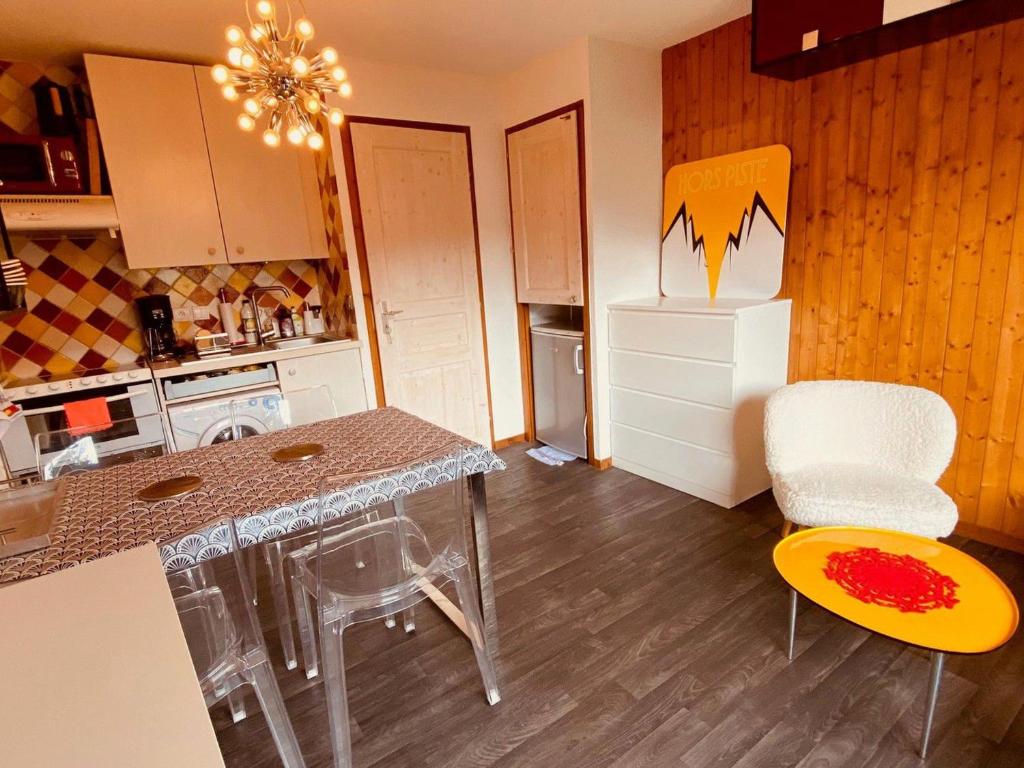 une cuisine avec une table, des chaises et un réfrigérateur dans l'établissement La Clusaz: Appartement cosy 4 pers, balcon, garage - FR-1-459-241, à La Clusaz