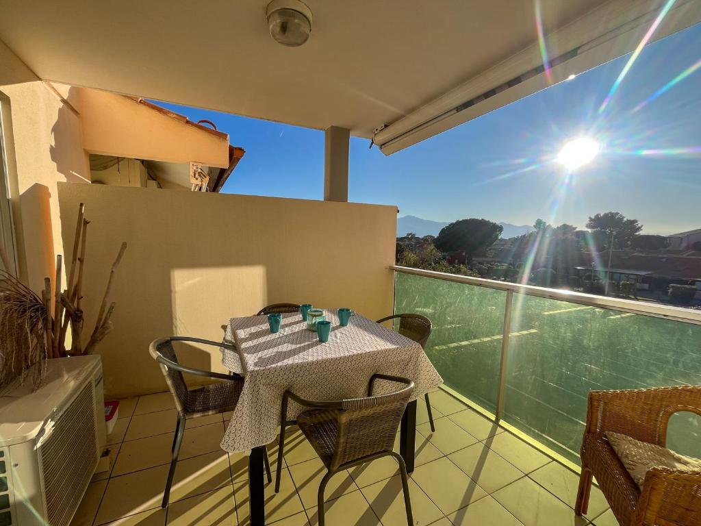 une table et des chaises sur un balcon avec vue dans l'établissement Appartement climatisé en bord de mer avec piscine et parking à Saint-Cyprien - FR-1-753-29, à Saint-Cyprien