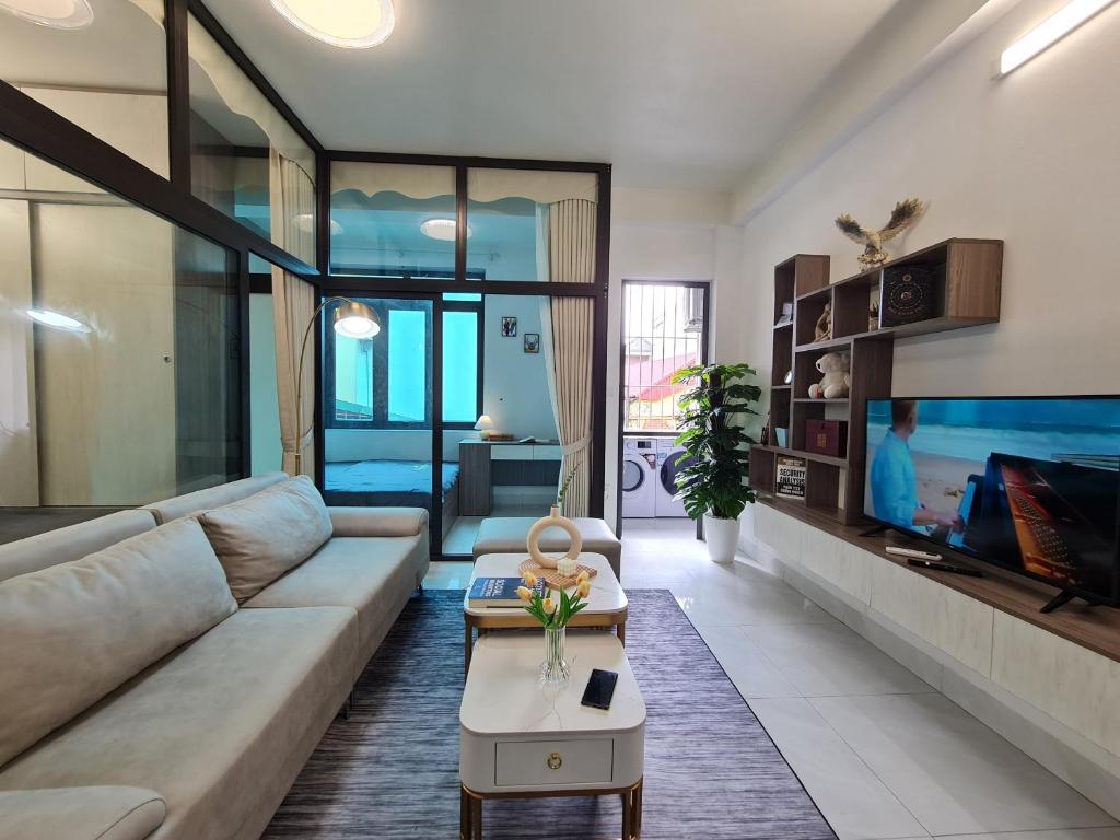 a living room with a couch and a tv at The Little'N Homestay Ha Noi 59 in Hanoi