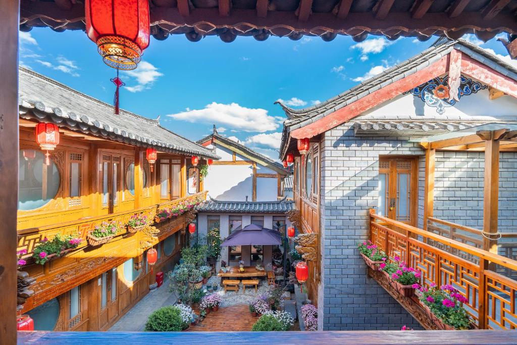 丽江Shile Inn的一栋老建筑的景色，里面有一张桌子和一把雨伞