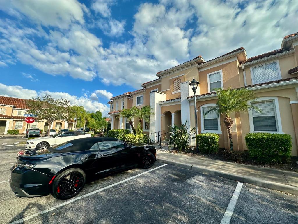 Ein schwarzes Auto parkte auf einer Straße vor Häusern in der Unterkunft Grand Panoramic 3BR Townhouse Near Disney Parks in Kissimmee