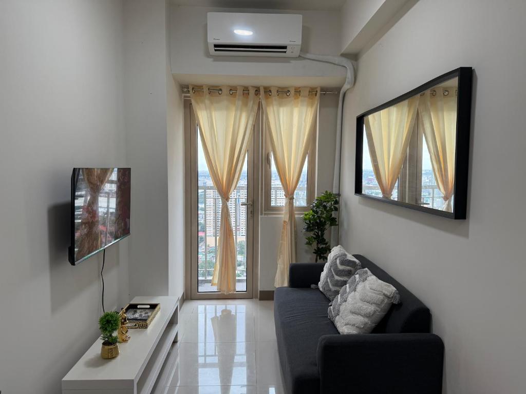 a living room with a couch and a window at Coast Residences Zeus Place in Manila