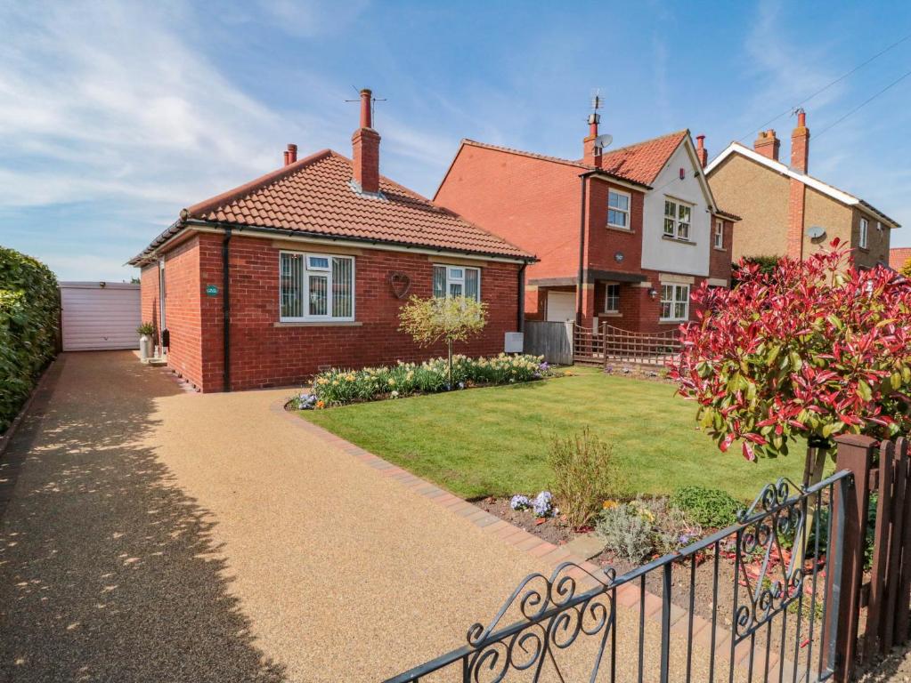 ein Backsteinhaus mit Zaun und Hof in der Unterkunft Field Cottage in York