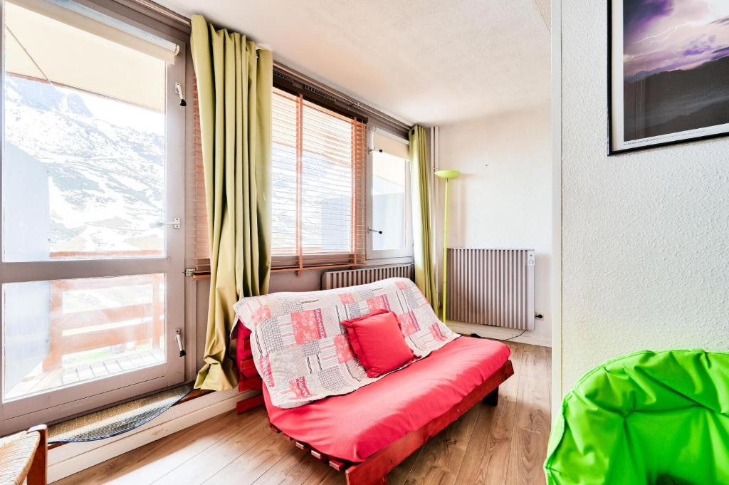 - un canapé rouge dans une chambre avec une grande fenêtre dans l'établissement Résidence Le Tourmalet - maeva Home - Appartement 2 pièces 6 personnes - Prestige MAE-3191, à La Mongie