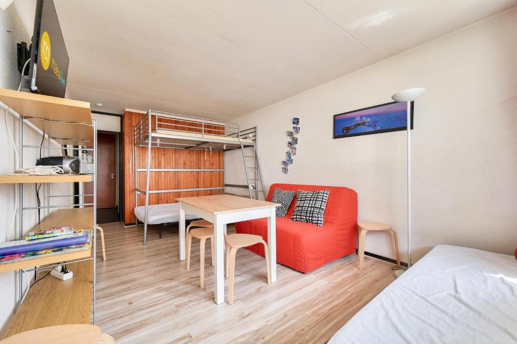 Cette chambre comprend un lit, une table, un lit et des lits superposés. dans l'établissement Résidence Le Tourmalet - maeva Home - Studio 6 personnes - Sélection MAE-0271, à La Mongie