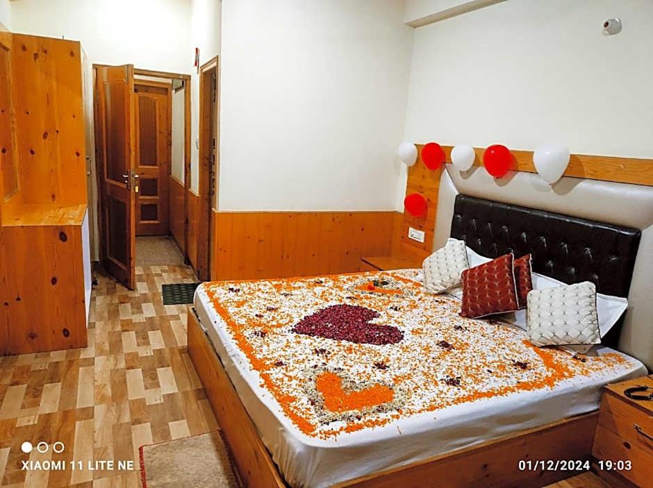 Un dormitorio con una cama grande cubierta de chispas. en Hotel Anchal Residency, en Manali
