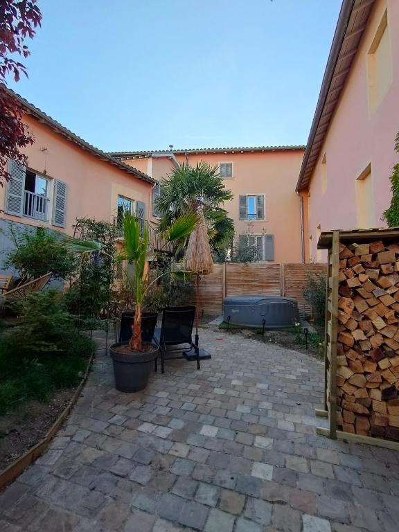 une cour avec deux potiers et un bâtiment dans l'établissement La Chamade en Beaujolais, à Anse