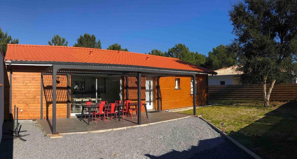 une maison dotée d'une terrasse avec des chaises et une table dans l'établissement Mimizan Plage 4 bedroom house with garden, à Mimizan-Plage