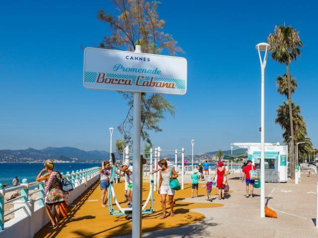 un groupe de personnes marchant sur une plage dans l'établissement La douceur Cannoise soit un 2P cosy terrasse piscine vue jardin proche plage à pied, à Cannes