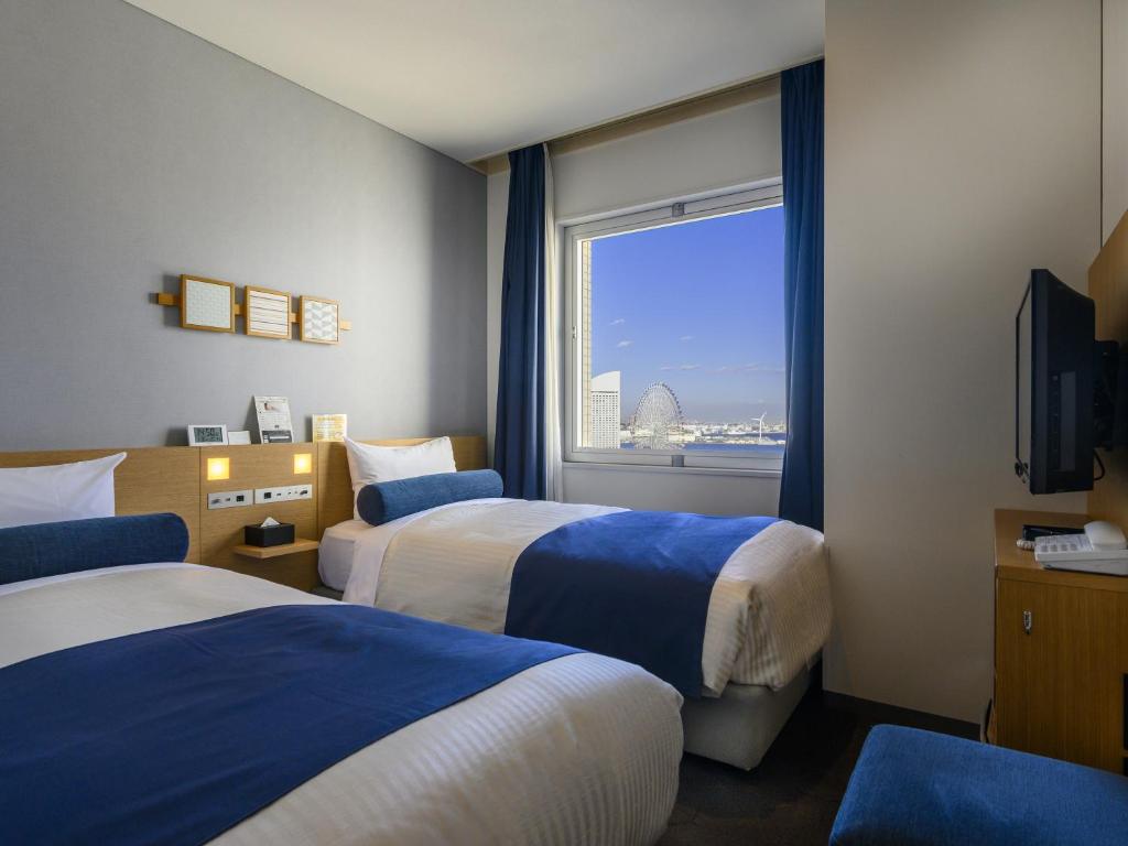 Postel nebo postele na pokoji v ubytování Yokohama Sakuragicho Washington Hotel