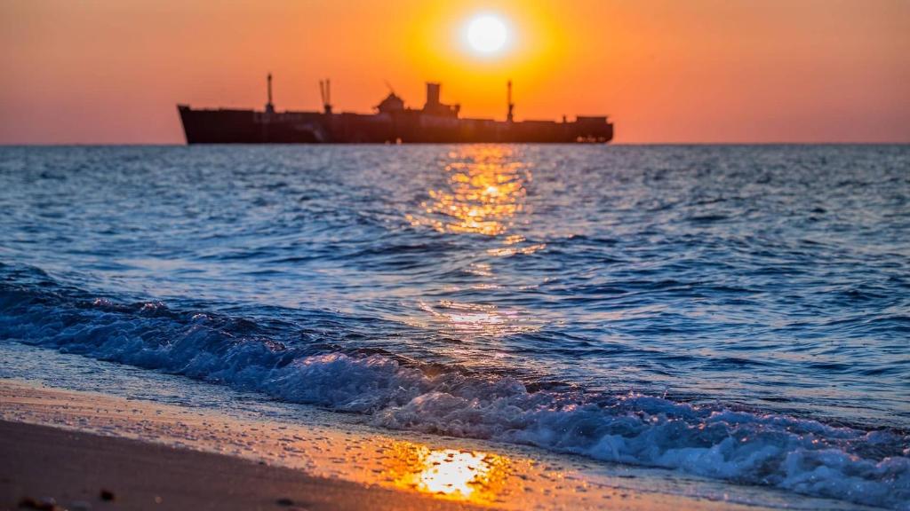 a ship in the ocean with the sunset in the background at I love Costinesti in Costinesti