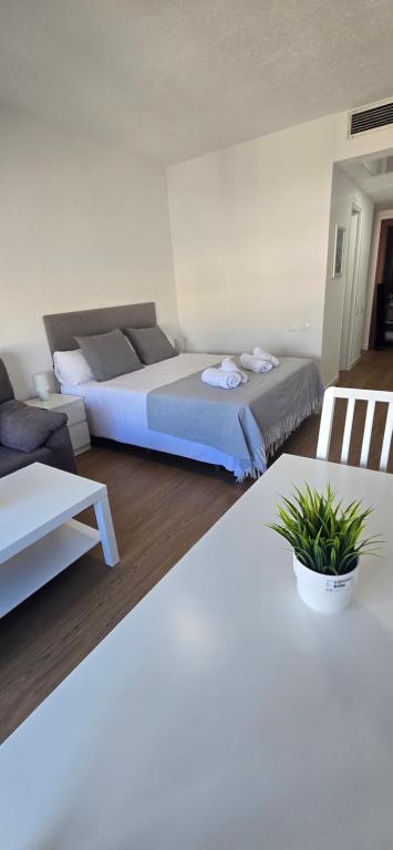 una camera da letto con due letti, un tavolo e un divano di Triana Apartahotel a Siviglia