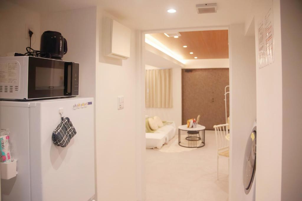 eine Küche mit einer Mikrowelle auf dem Kühlschrank in der Unterkunft 森下小屋 in Tokio