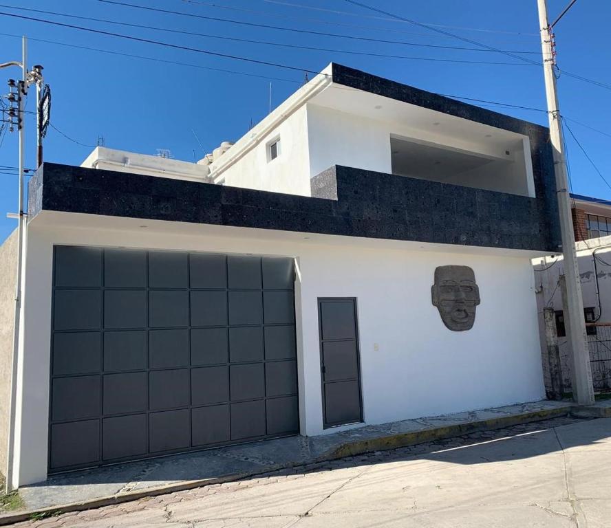 a white building with two garage doors on it at Posada CasaBlanca in San Sebastian Xolalpa