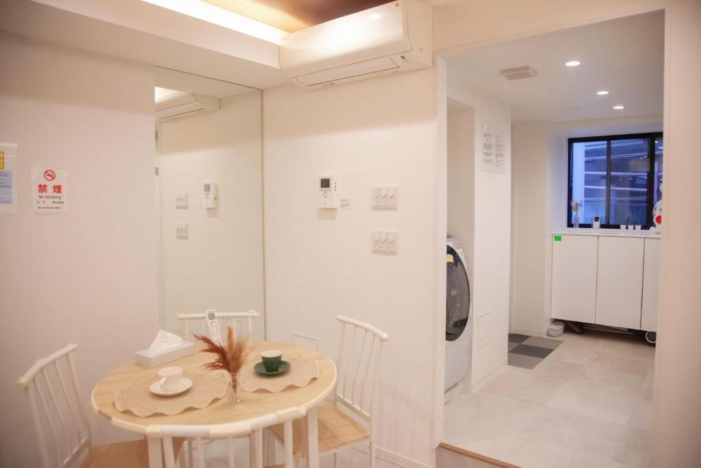 ein weißes Zimmer mit einem Tisch und einer Waschmaschine in der Unterkunft 森下小屋 in Tokio