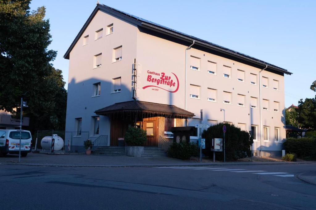a white building with a sign on the side of it at Gasthaus zur Bergstrasse in Hirschberg an der Bergstraße
