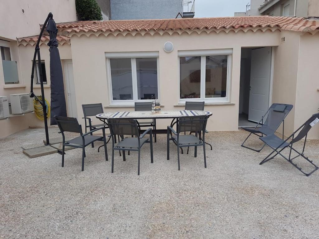 une table et des chaises devant une maison dans l'établissement Grau d'Agde Maison à 1 min plage, au Grau-dʼAgde