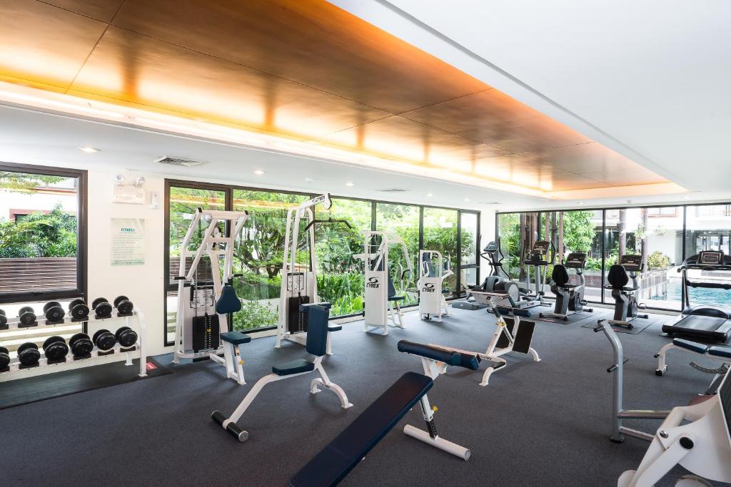 A bright, glass-walled fitness room with cardio and strength equipment.