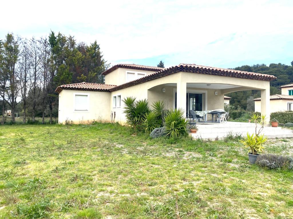 une maison blanche avec une cour gazonnée devant elle dans l'établissement Magnifique villa au calme a St Mitres les Remparts, à Saint-Mitre-les-Remparts