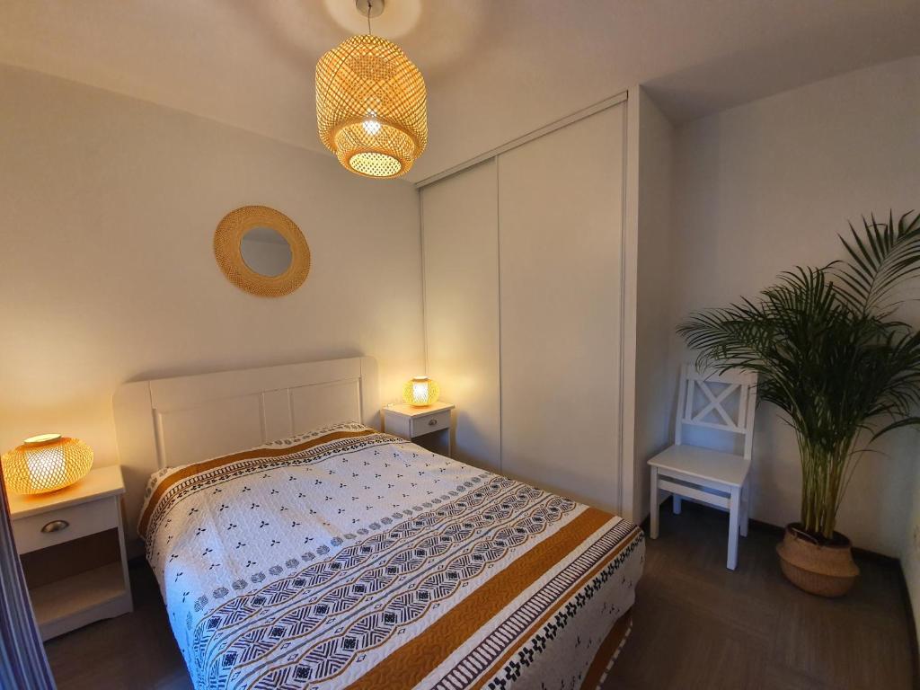 une chambre avec un lit et une plante en pot dans l'établissement Appartement T2 climatisé Piscine, à Gréoux-les-Bains