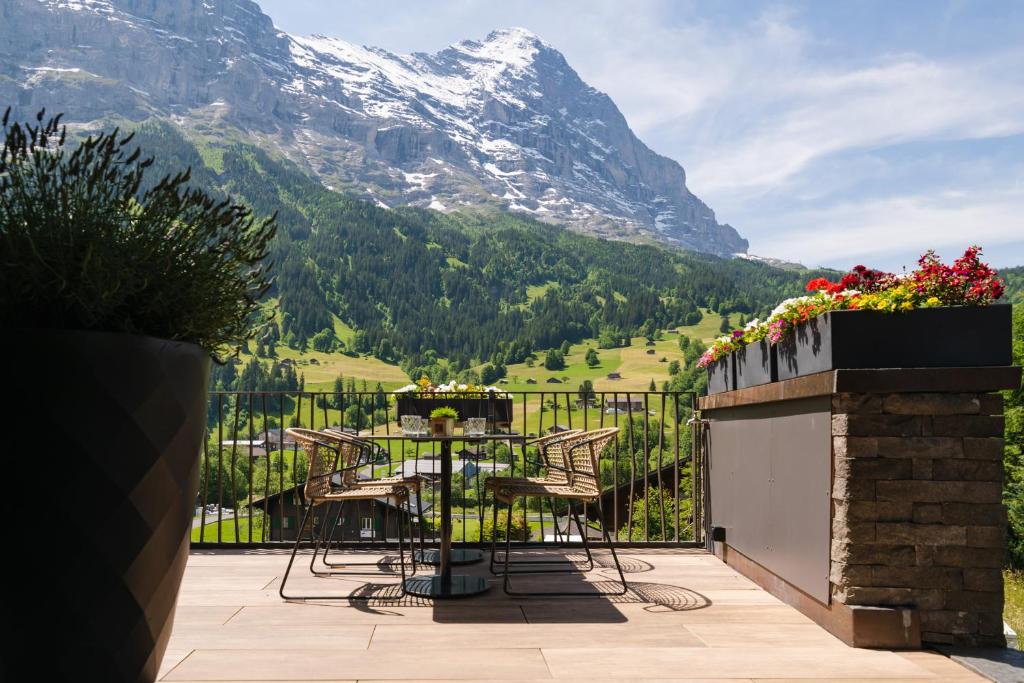 a table and chairs on a balcony with a mountain at Boutique Hotel Glacier in Grindelwald