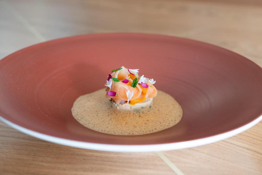 a small dessert in a red bowl on a table at Boutique Hotel Glacier in Grindelwald
