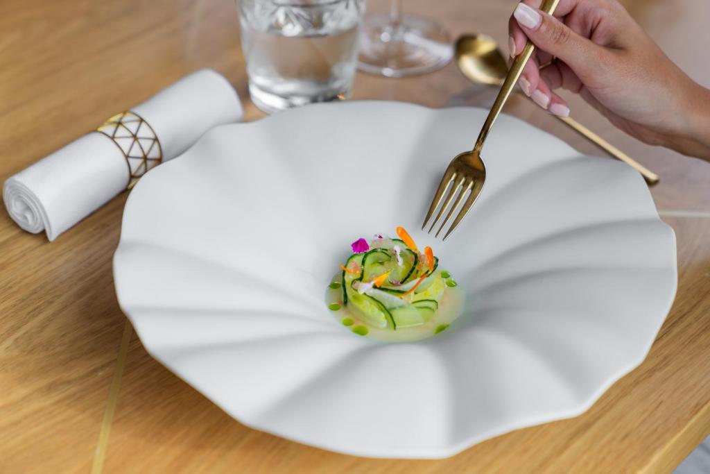 a person eating food on a plate with a fork at Boutique Hotel Glacier in Grindelwald