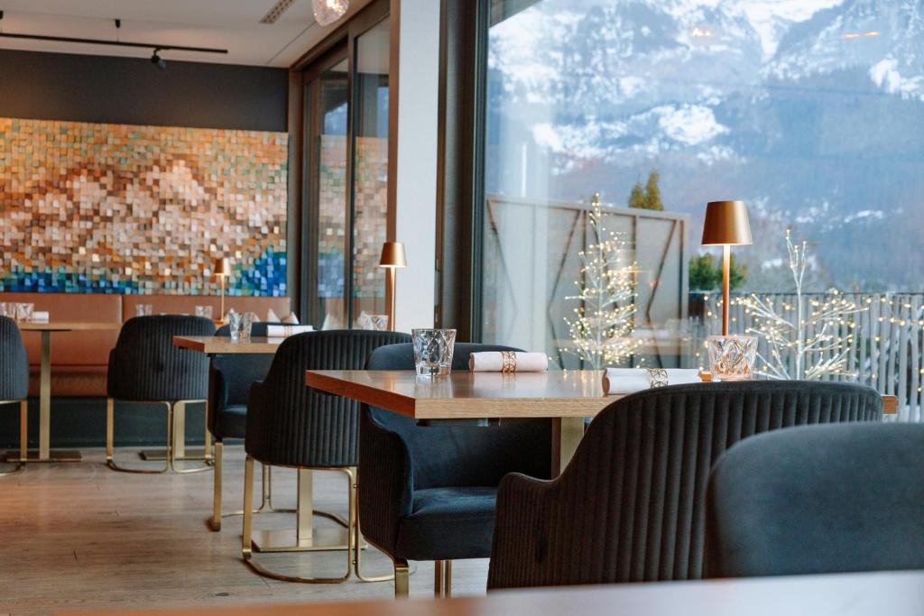 a restaurant with tables and chairs and a christmas tree at Boutique Hotel Glacier in Grindelwald