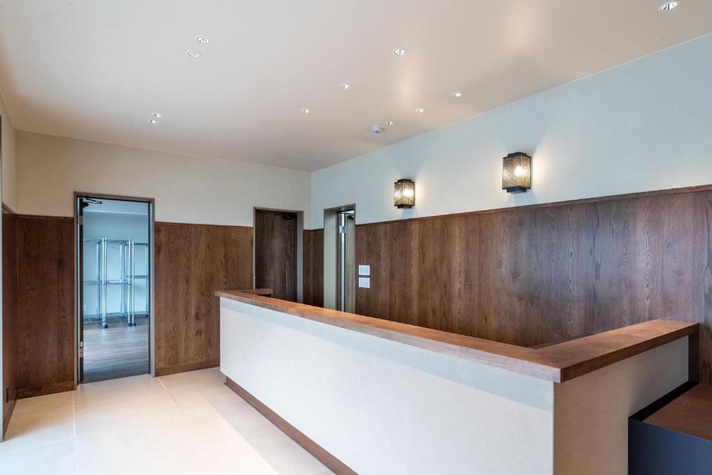 宮古島にあるApartment Hotel 11 Miyakojimaのウッドパネルのロビーとフロントデスク