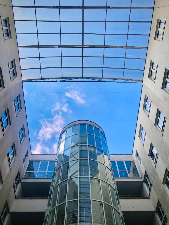 a tall glass building with the sky in the middle at Hotel Astorka in Brno