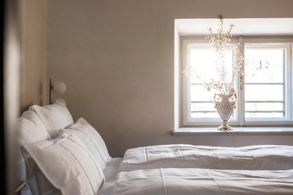 a bedroom with a bed and a window with a vase at Ansitz Thierburg Suites in Merano